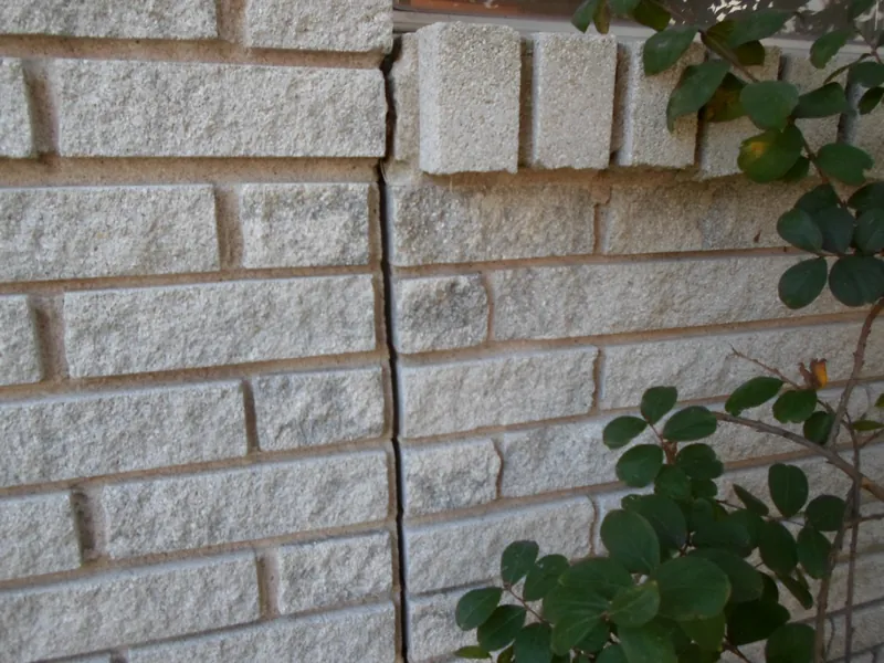 A vertical crack running through the brick veneer of a Houston home