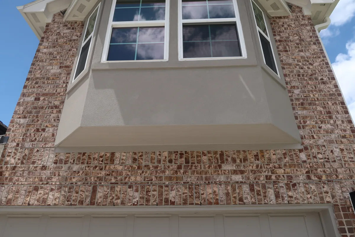 The brick veneer and bay window of a new Houston home under construction