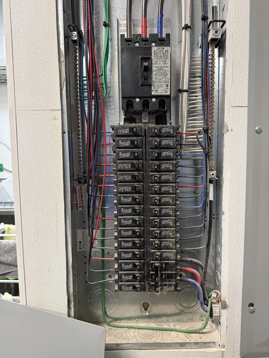 An electrical panel with the cover removed, breakers and wiring checked during a phase inspection