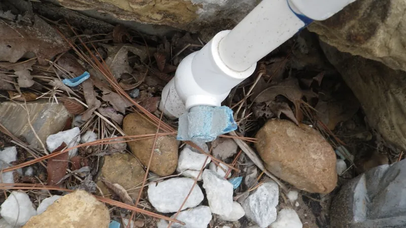 A pool plumbing fitting and pipe at ground level, checked during an inspection